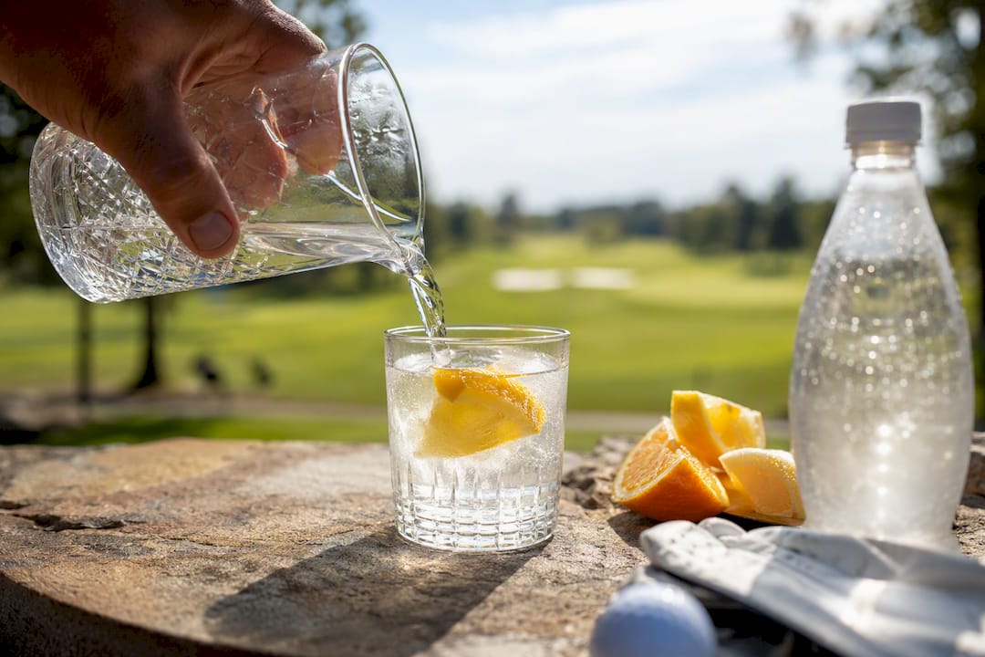 Golfer pouring low sugar cocktail outdoors