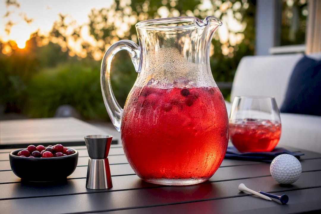 Pitcher of batched vodka cocktail with lemon garnish