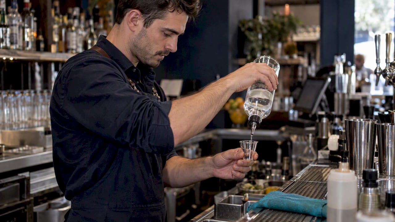 Bartender checks a free pour in a marked cup