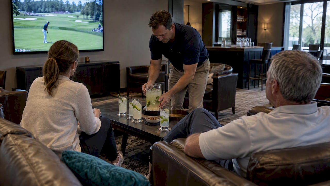 Guests watch golf beside a pitcher of cocktails