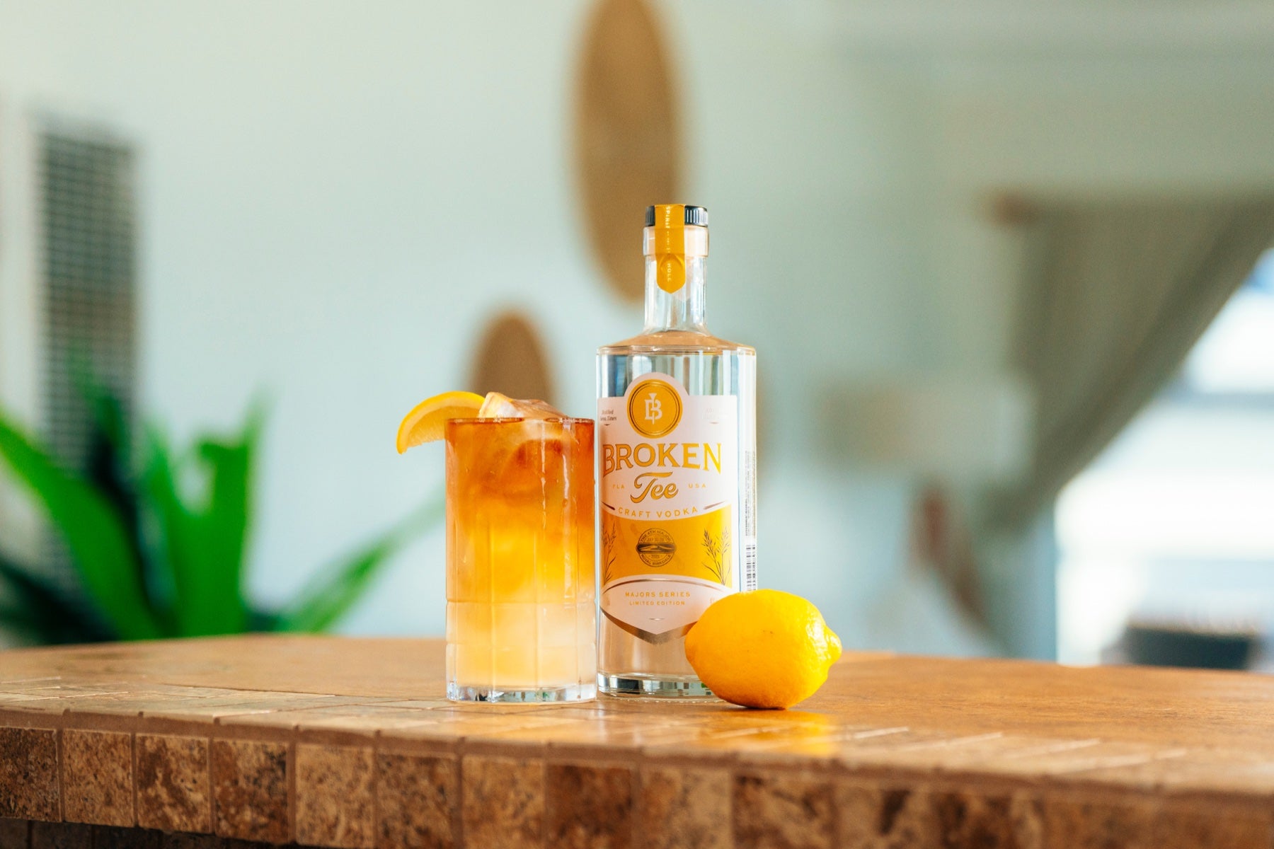 The Open First Edition bottle with cocktail and citrus